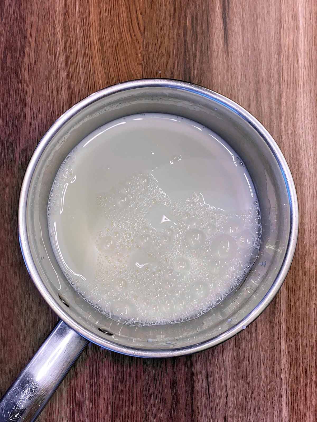 A saucepan containing milk.