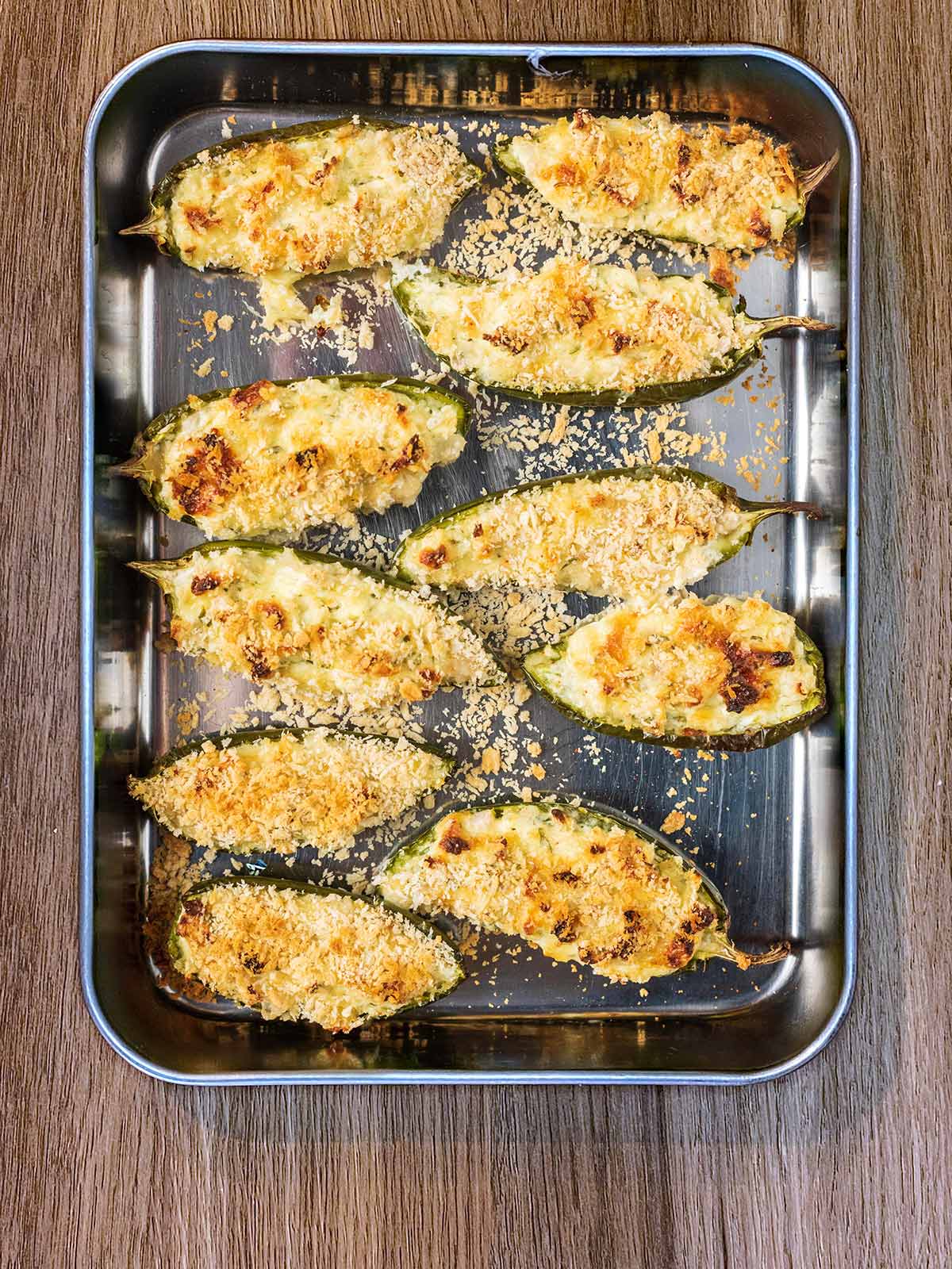Baked jalapeno poppers on a baking tray.