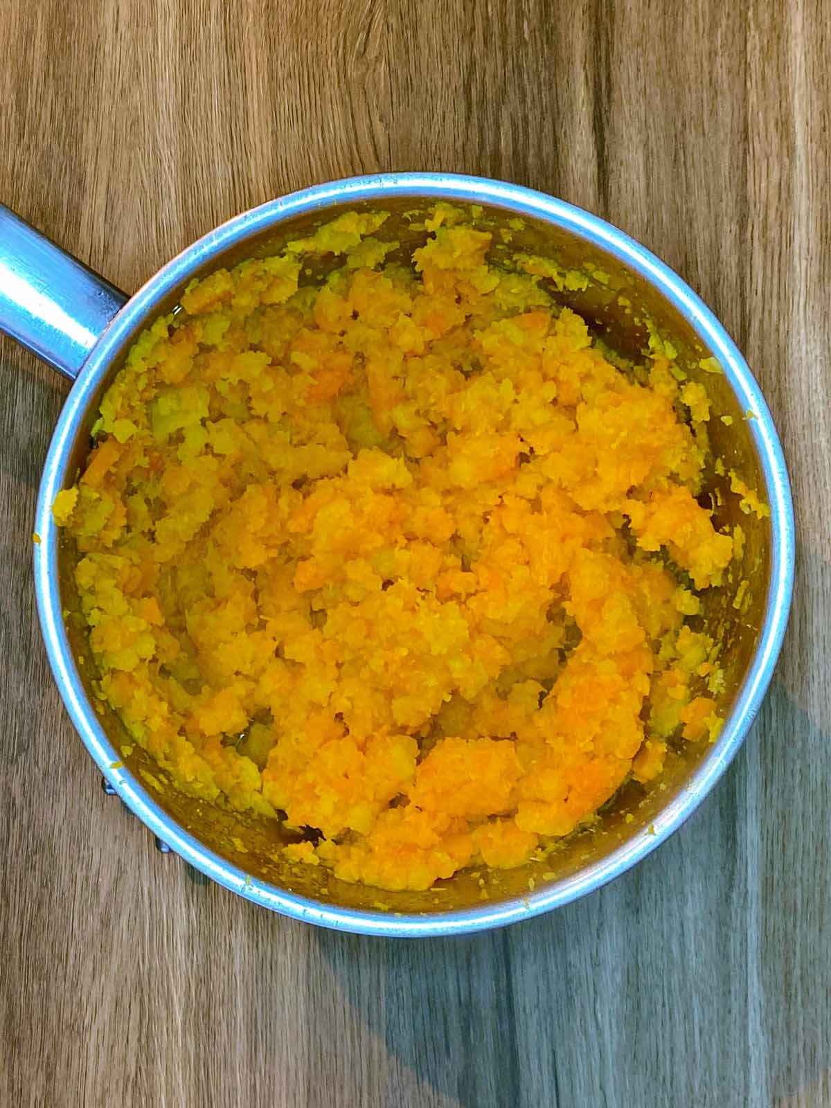 Mashed carrot and swede in a saucepan.