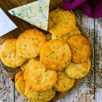 Cheese biscuits on a board with some Stilton.