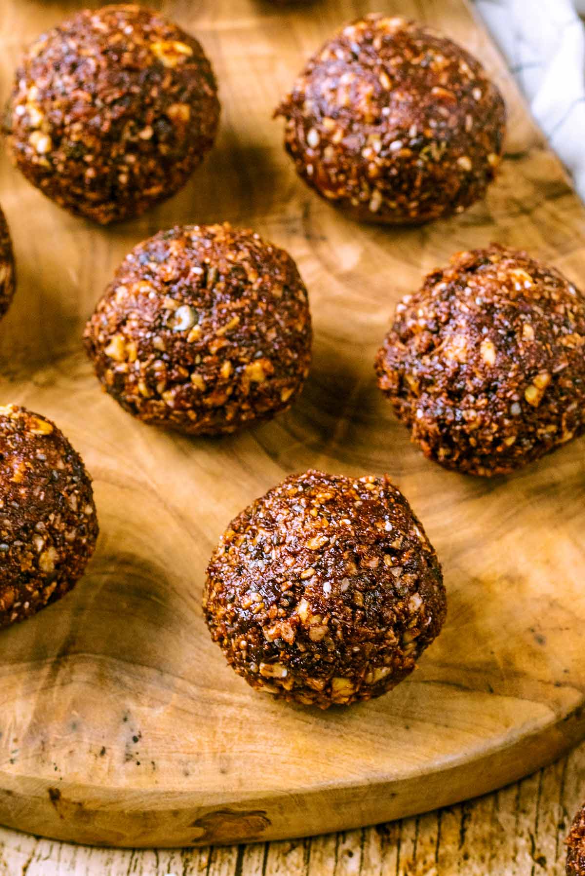 Energy balls on a wooden serving board.