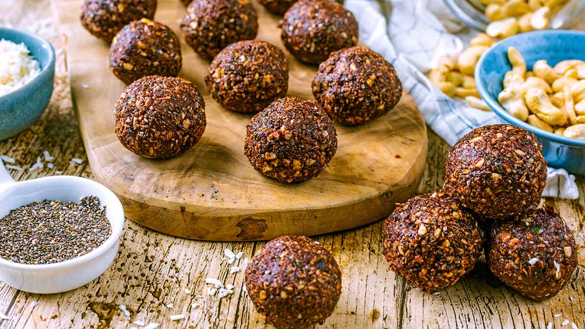 No bake chocolate energy balls on a wooden board.