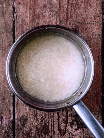 A saucepan containing rice and water.