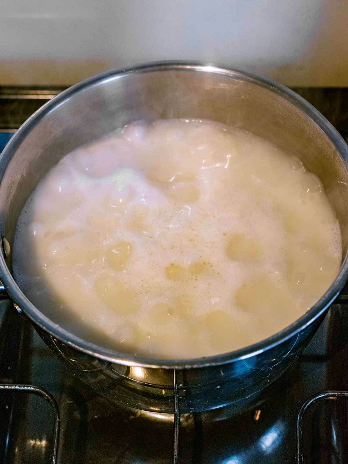 A pan of rice boiling on a hob.
