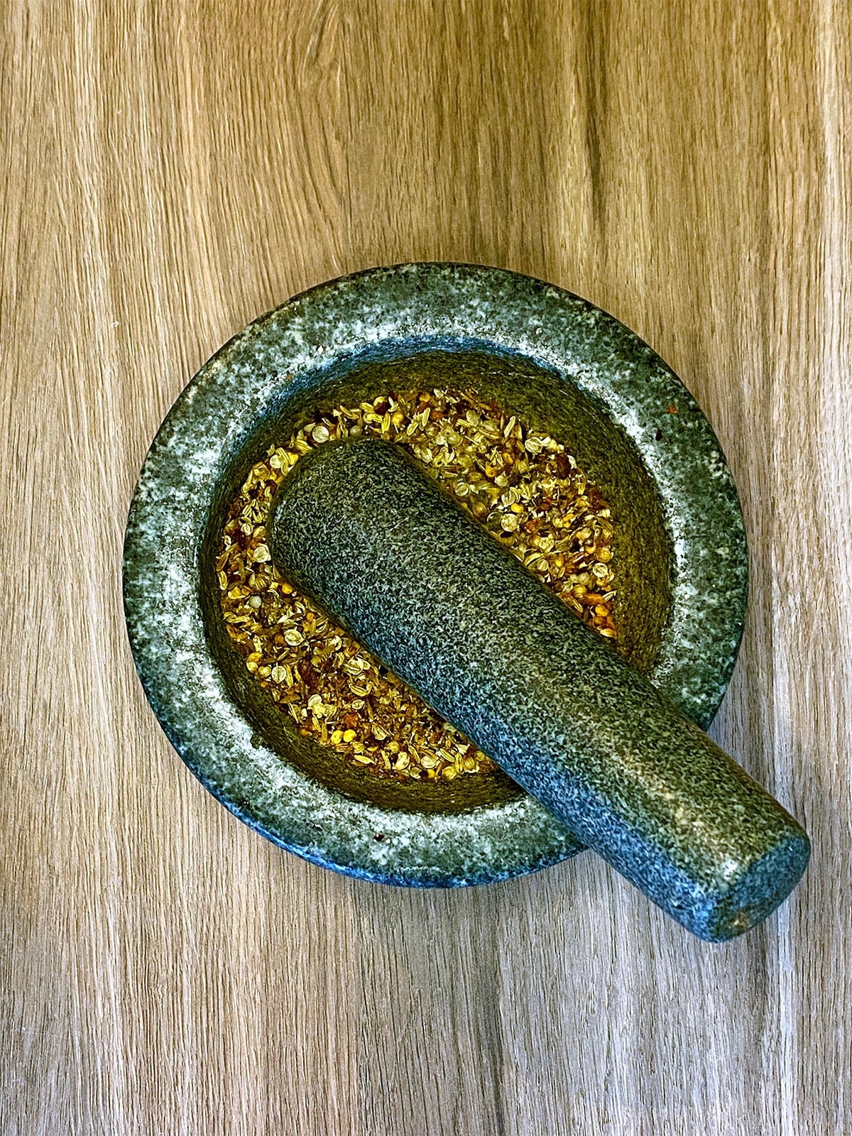 Toasted spices in a pestle and mortar.