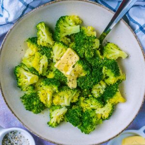 Microwave broccoli in a bowl with a spoon.