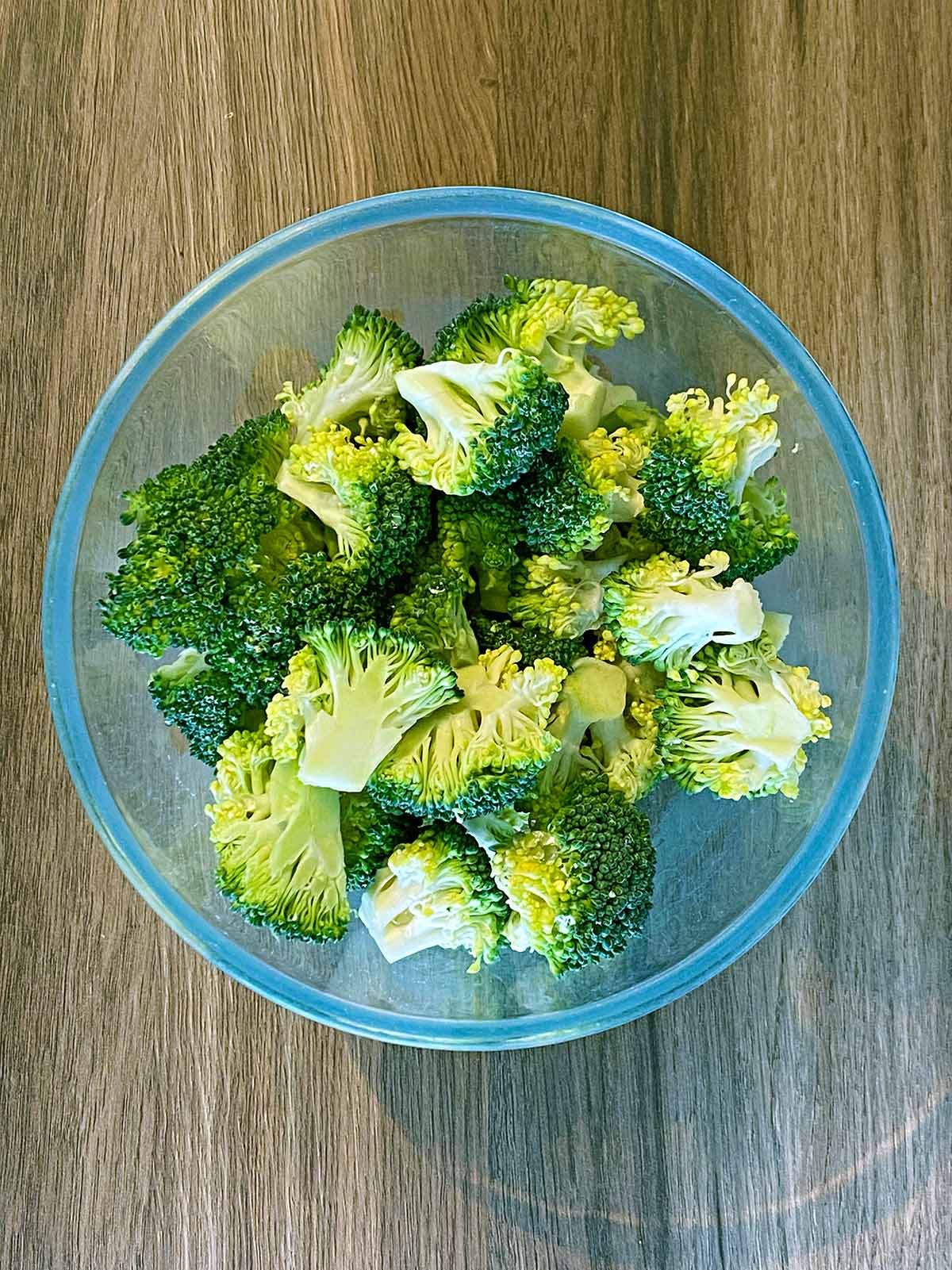 Broccoli florets in a glass bowl.