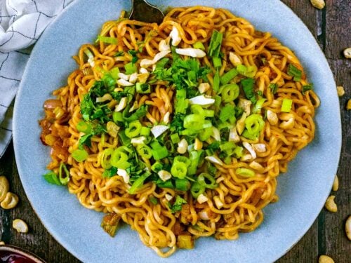 A plate of spicy noodles with a fork in them.