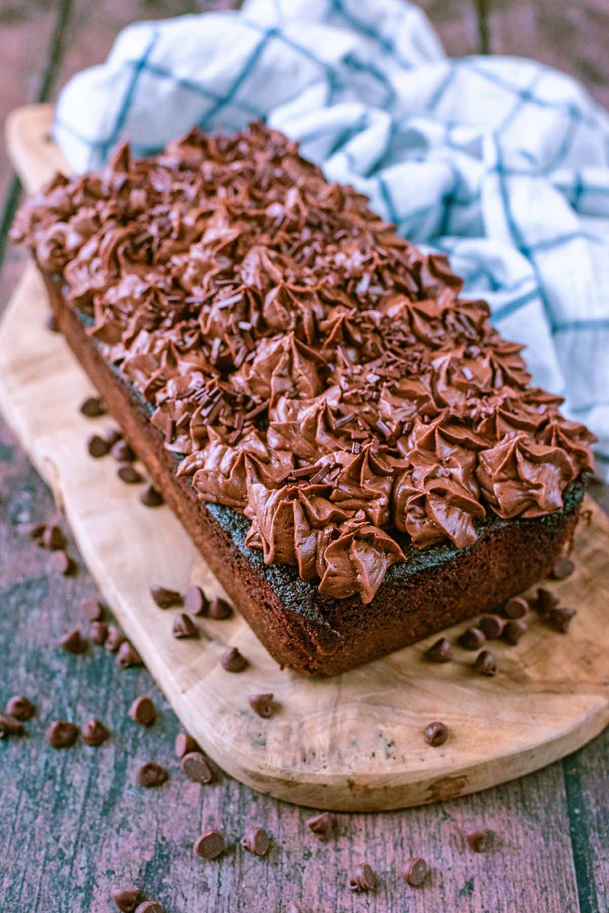 A rectangular chocolate cake topped with chocolate icing and chocolate sprinkles.