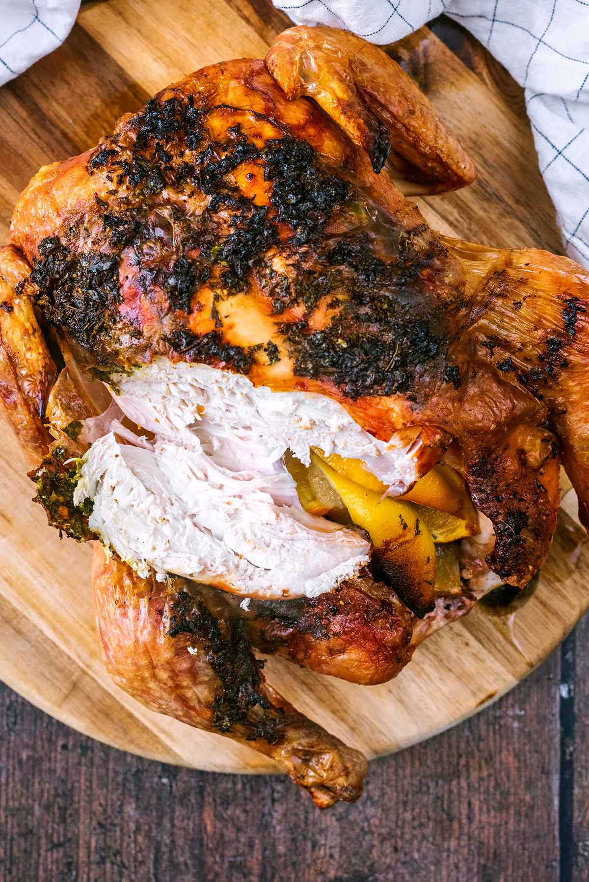 A roast chicken with part of the breast sliced off.