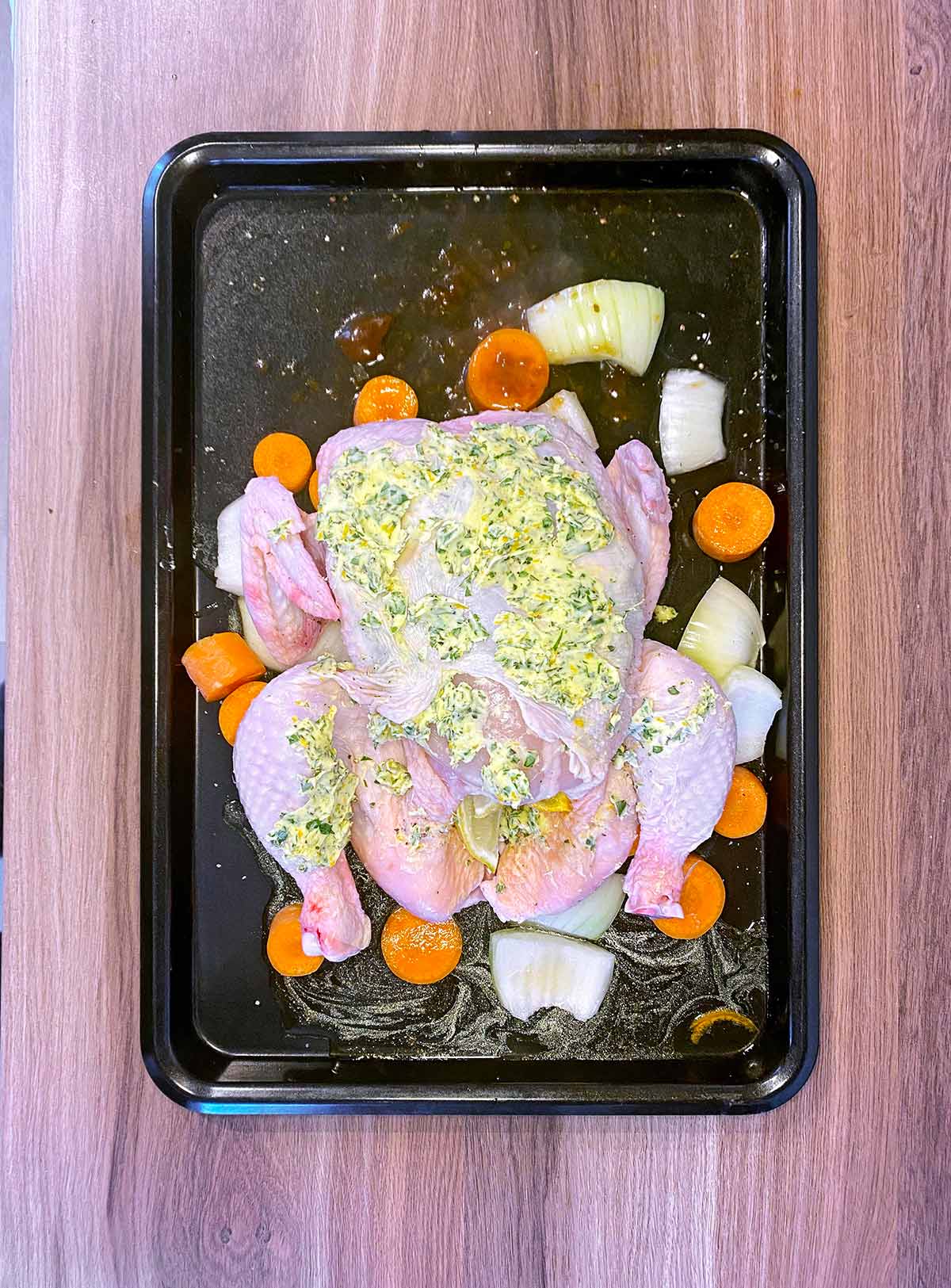 A whole chicken smothered in herb butter.