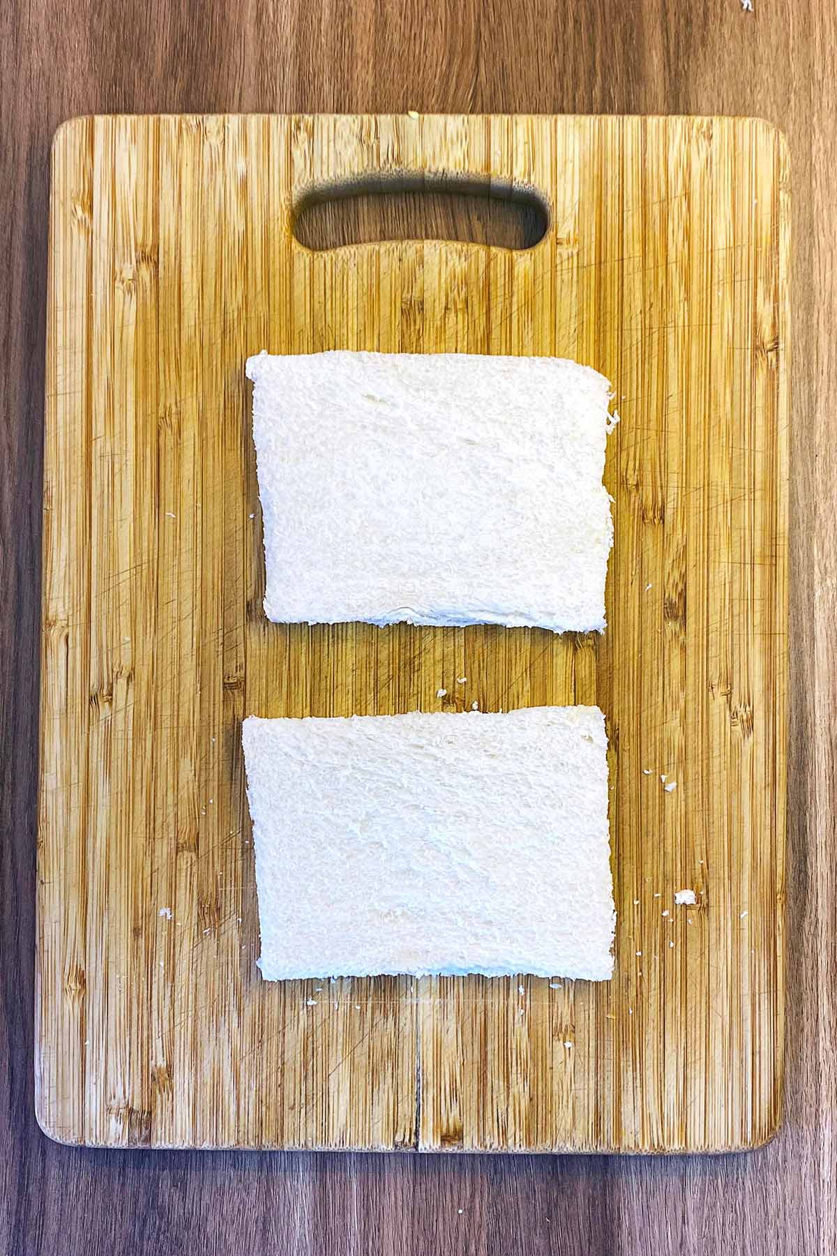 Two slices of white bread with their crusts removed.