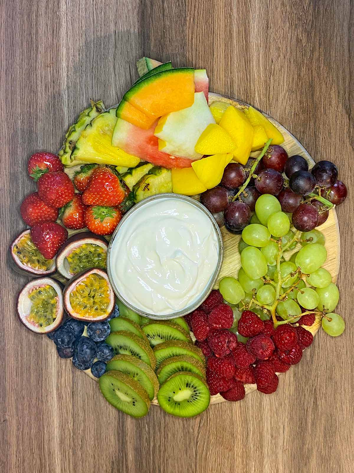 Various fruit added to the board surrounding the dip.