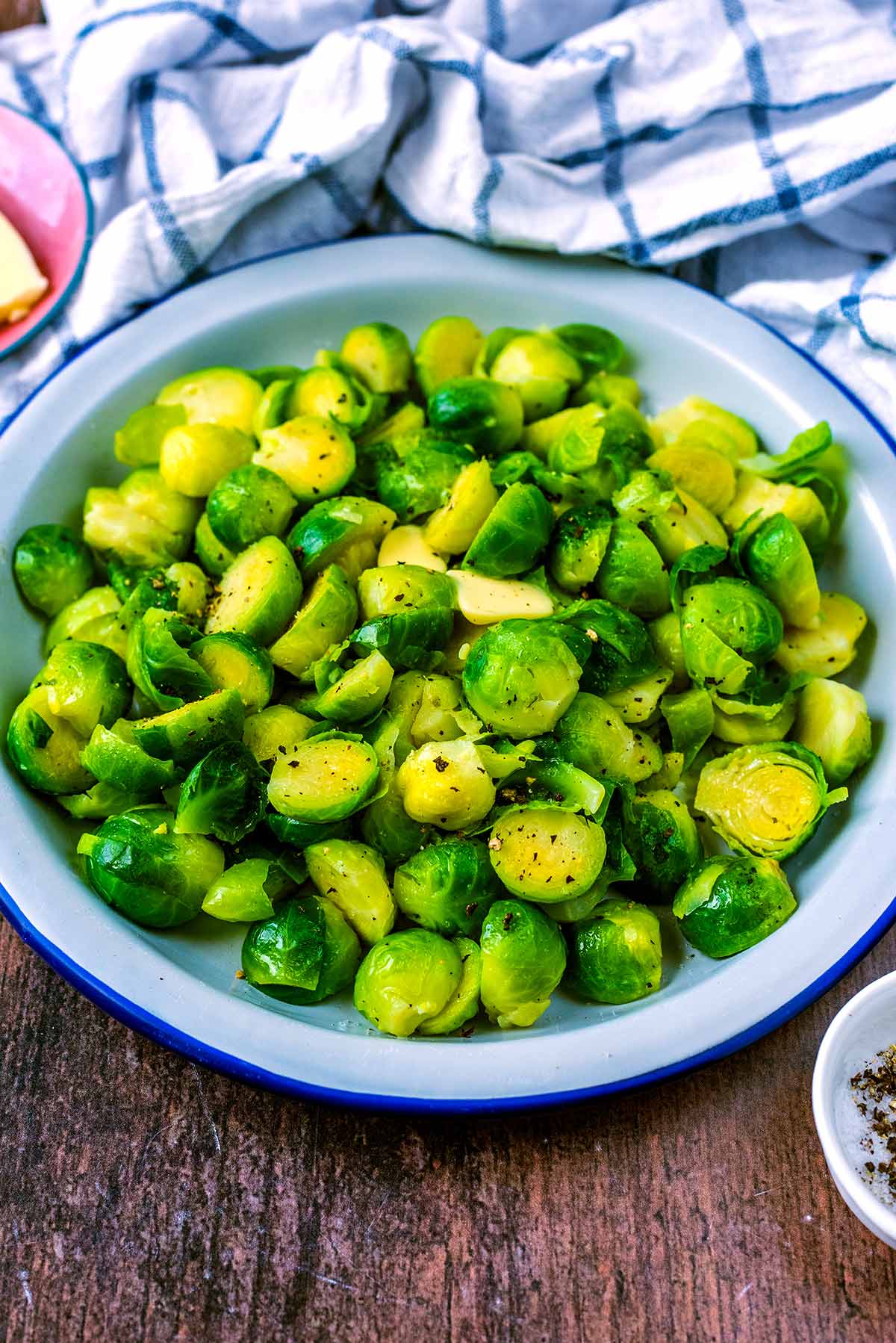 A bowl of Brussels sprouts in front of a towel.