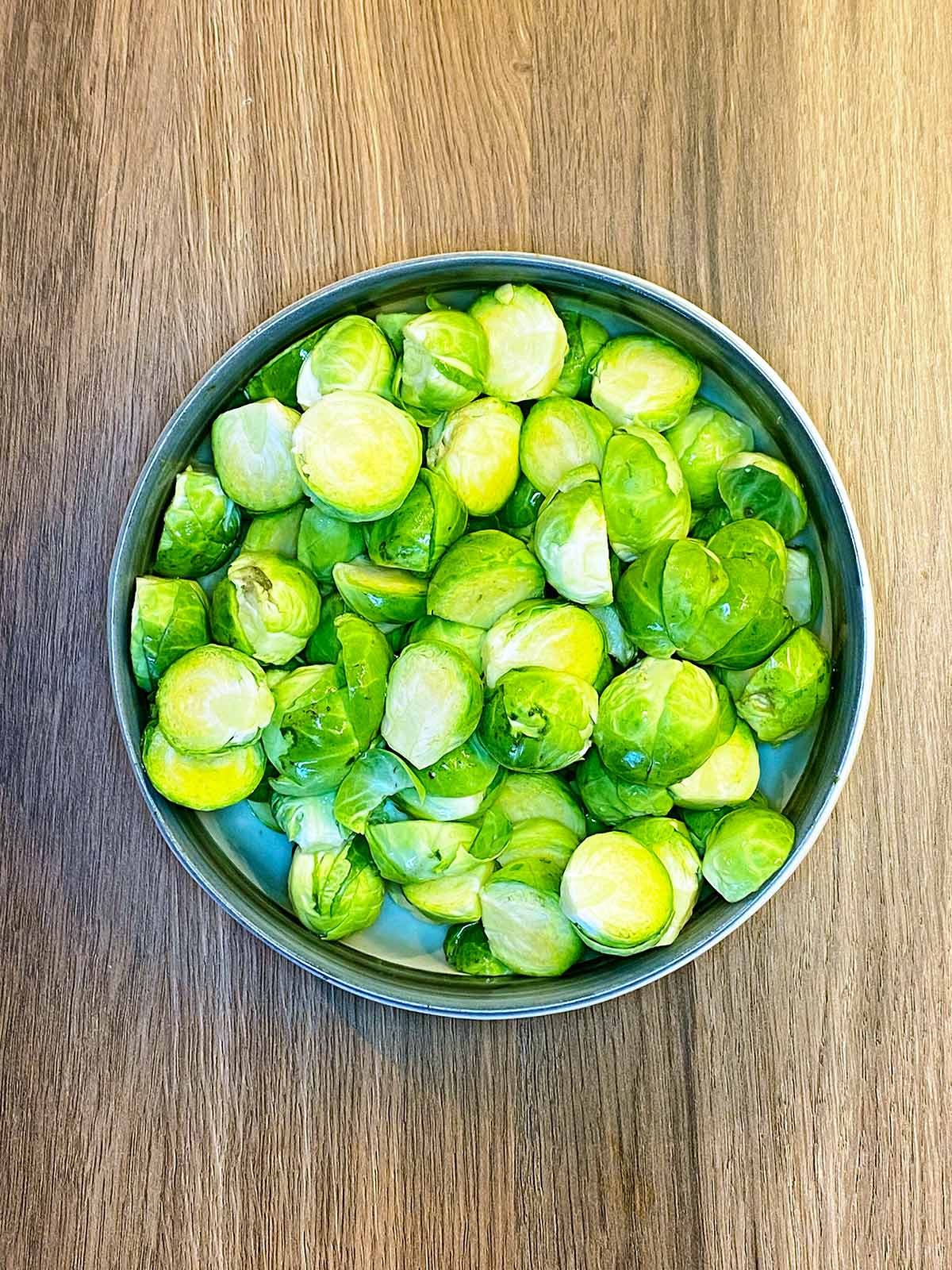 A bowl of Brussels sprouts that have been cut in half.