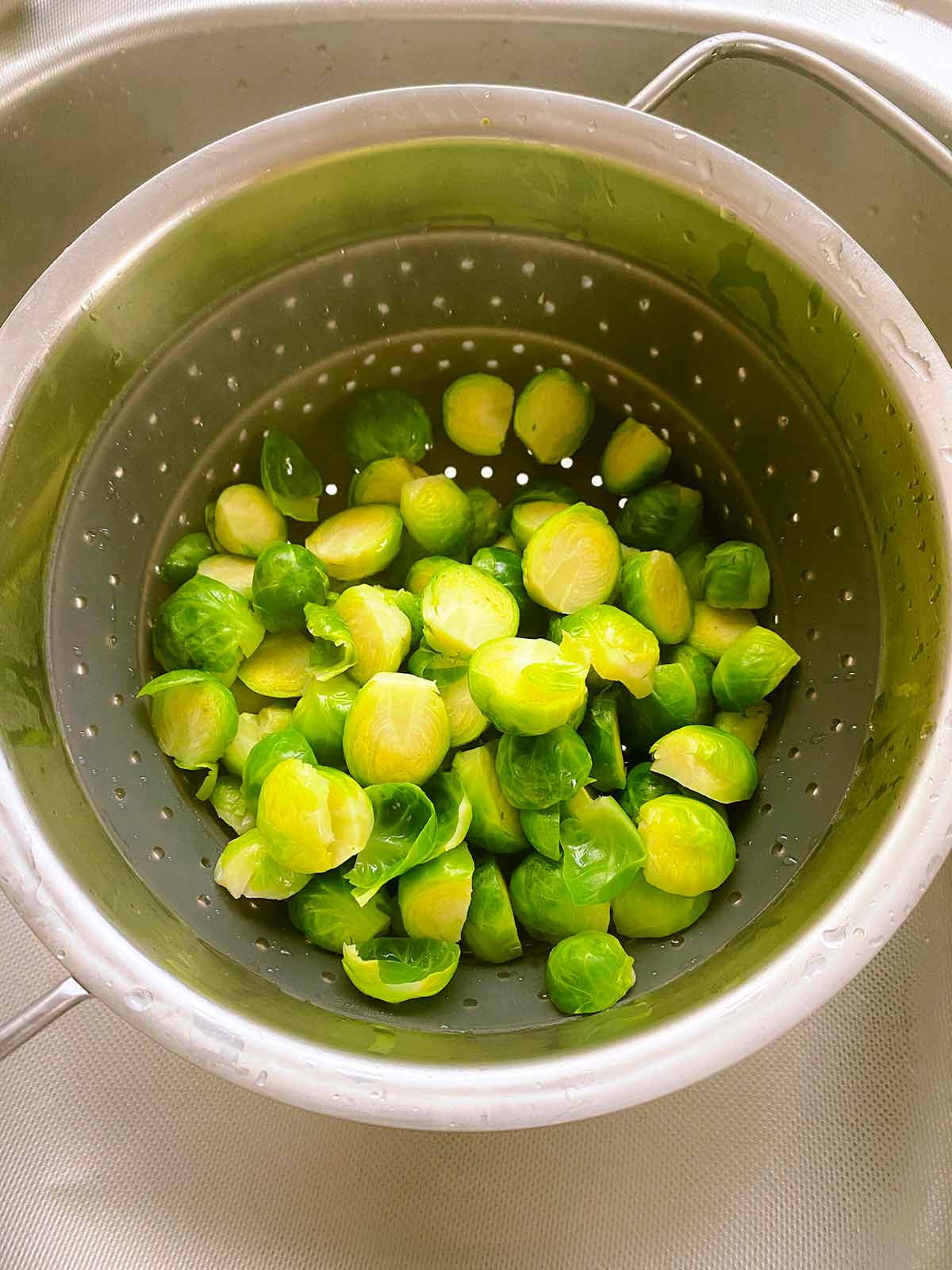 Cooked Brussels sprouts in a collander.