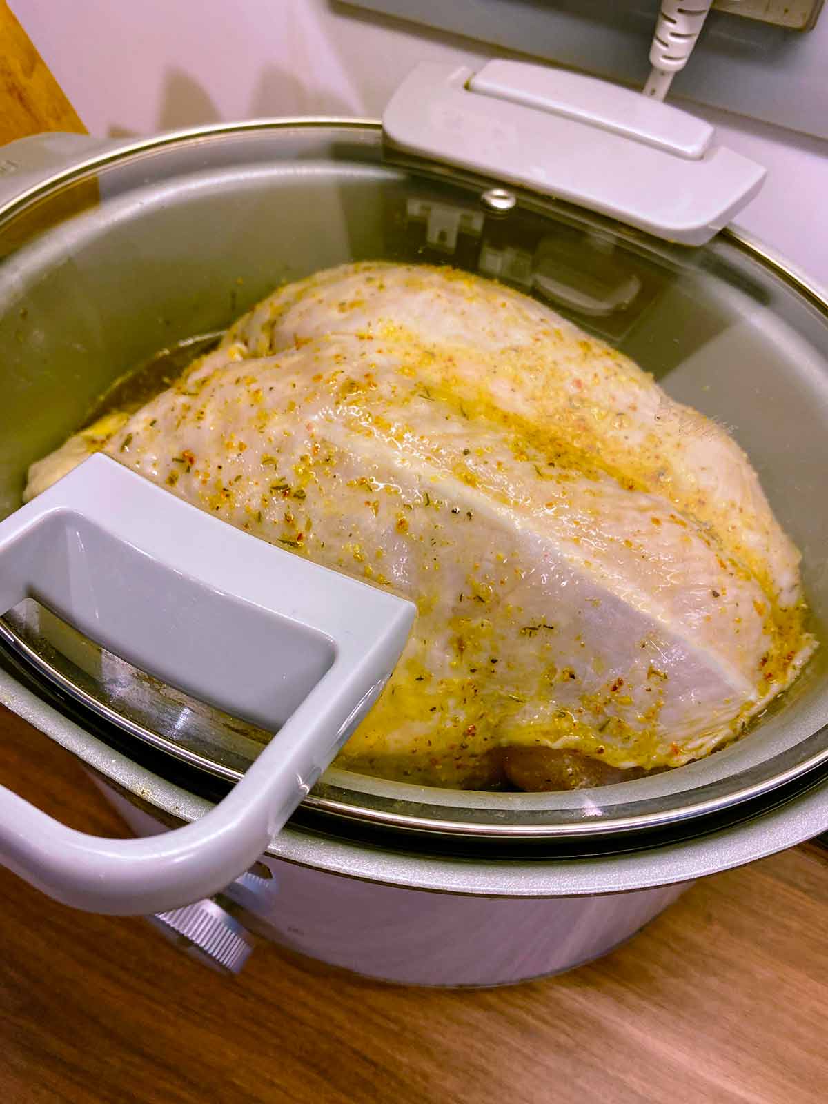 A turkey crown cooking in a slow cooker.