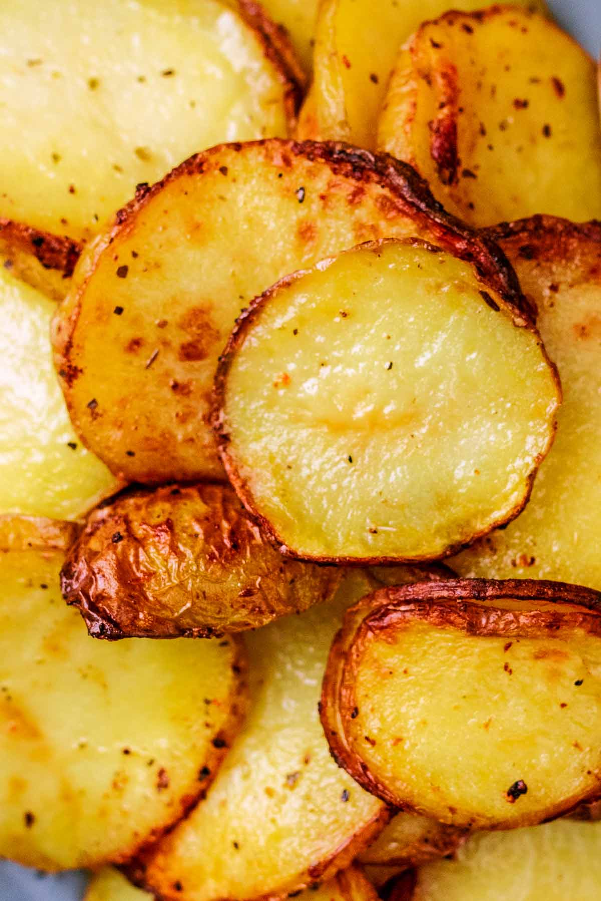 Thin cooked potato slices with slightly blackened edges.