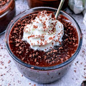 Chocolate pots topped with whipped cream and chocolate shavings.