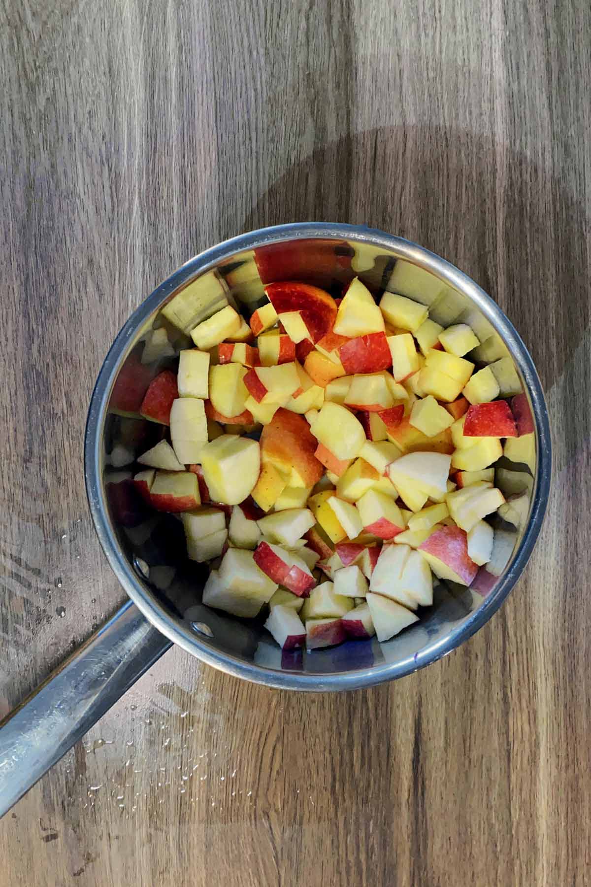 A saucepan with chopped apples in it.