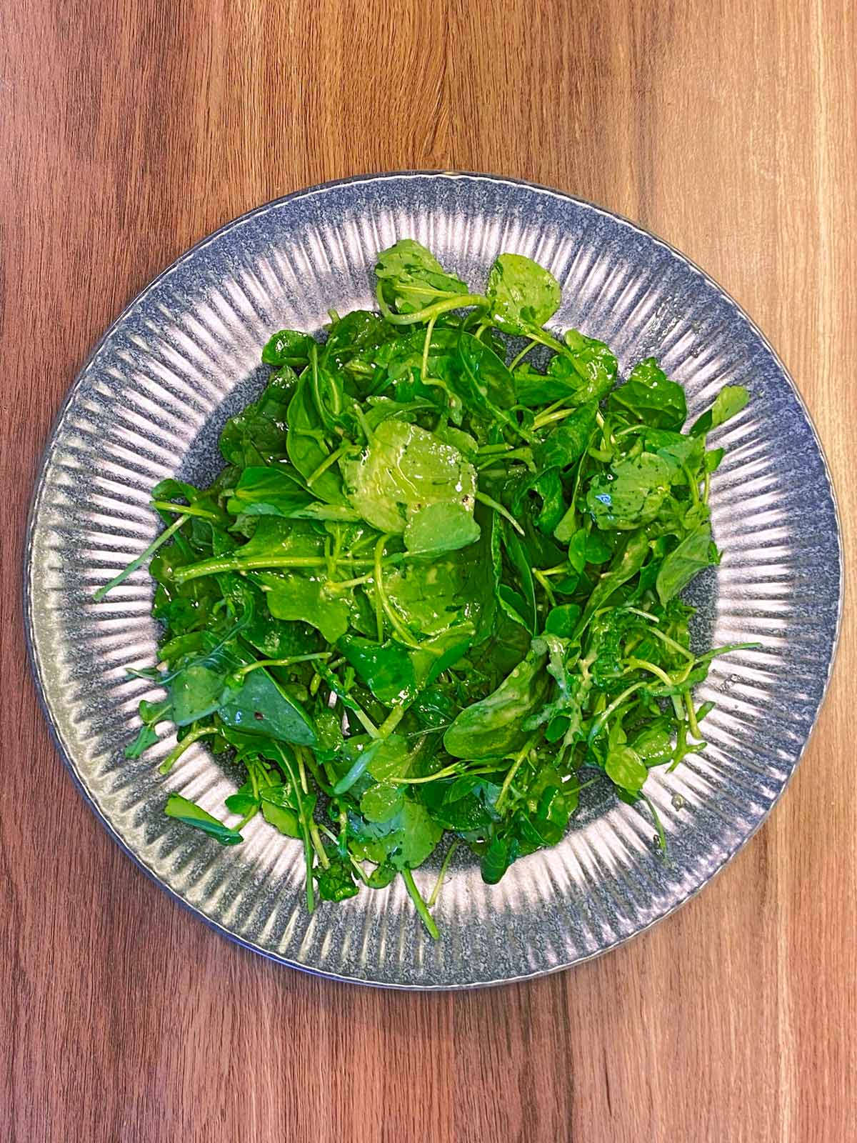 Dressed salad leaves on a plate.