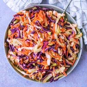 The best homemade coleslaw on a plate with a fork.