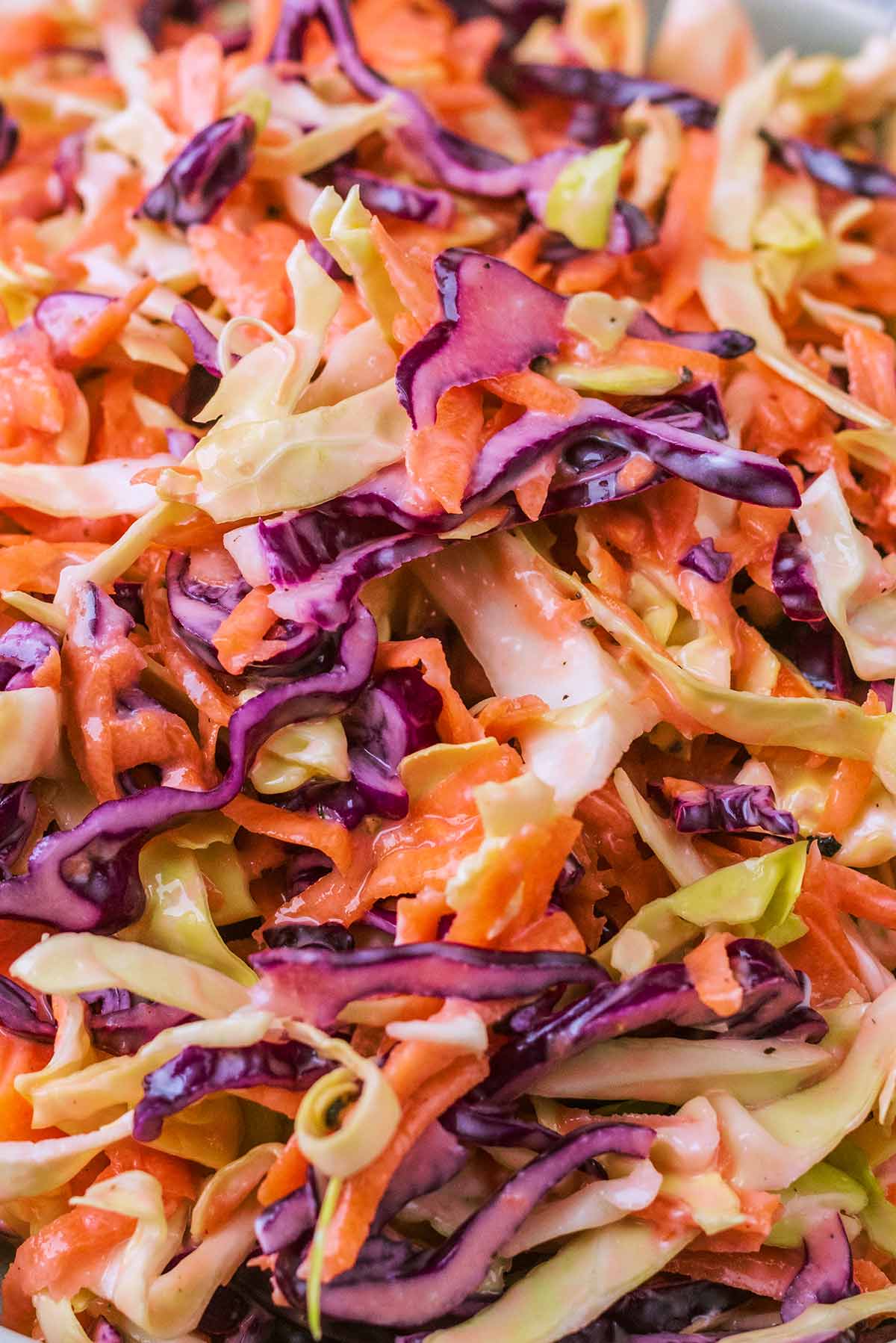Shredded red and white cabbage and shredded carrot all mixed together.