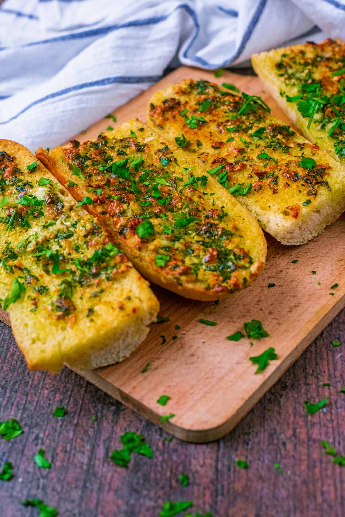 Slices of garlic bread in front of a striped towel.