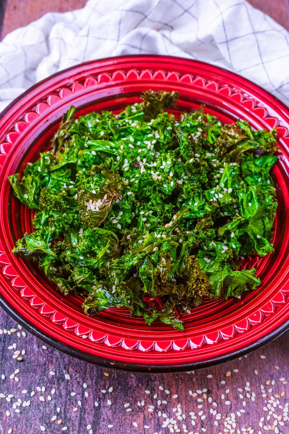 A bowl of kale in front of a towel.