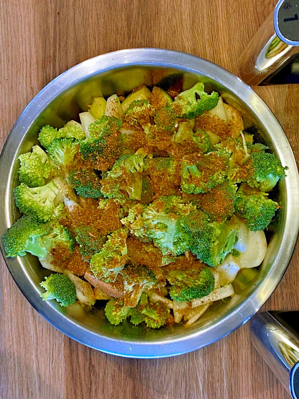 Chopped vegetables in a bowl covered in seasoning.