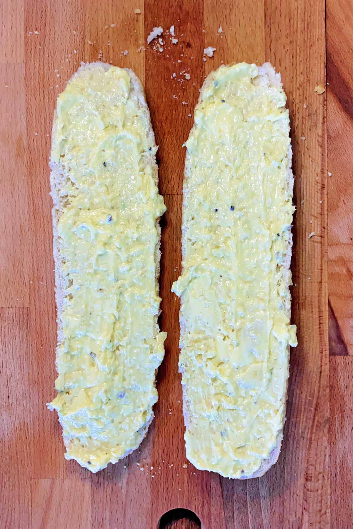 A french stick halved and spread with garlic butter.