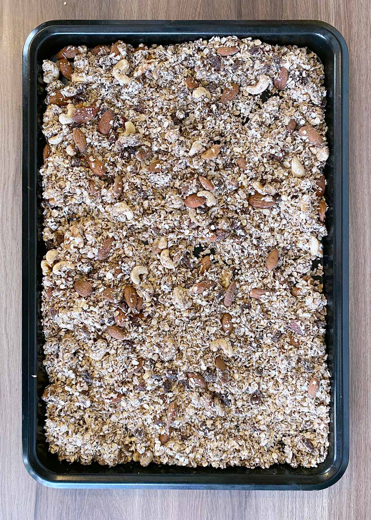 Mixed granola spread over a baking tray.