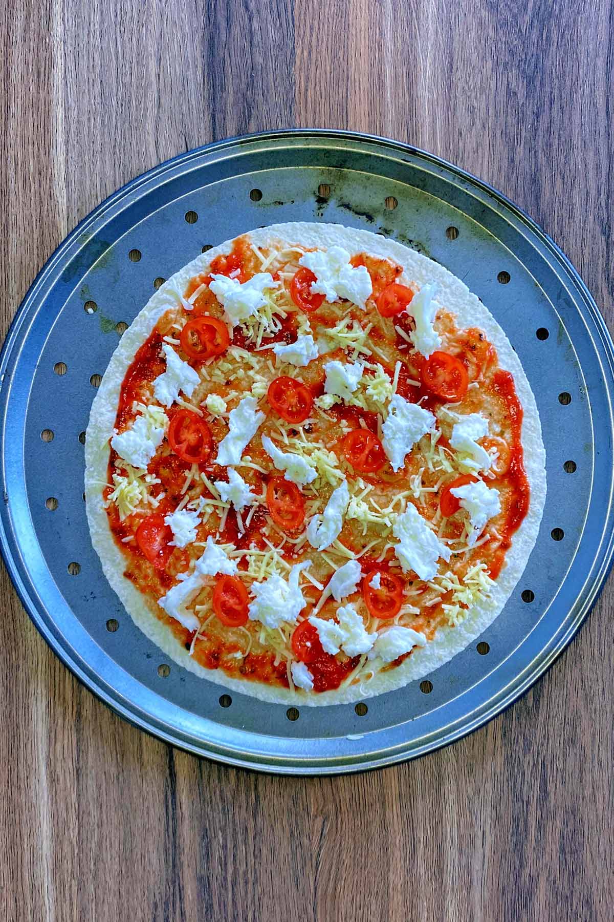 Cheese and sliced tomatoes added to the pizza.