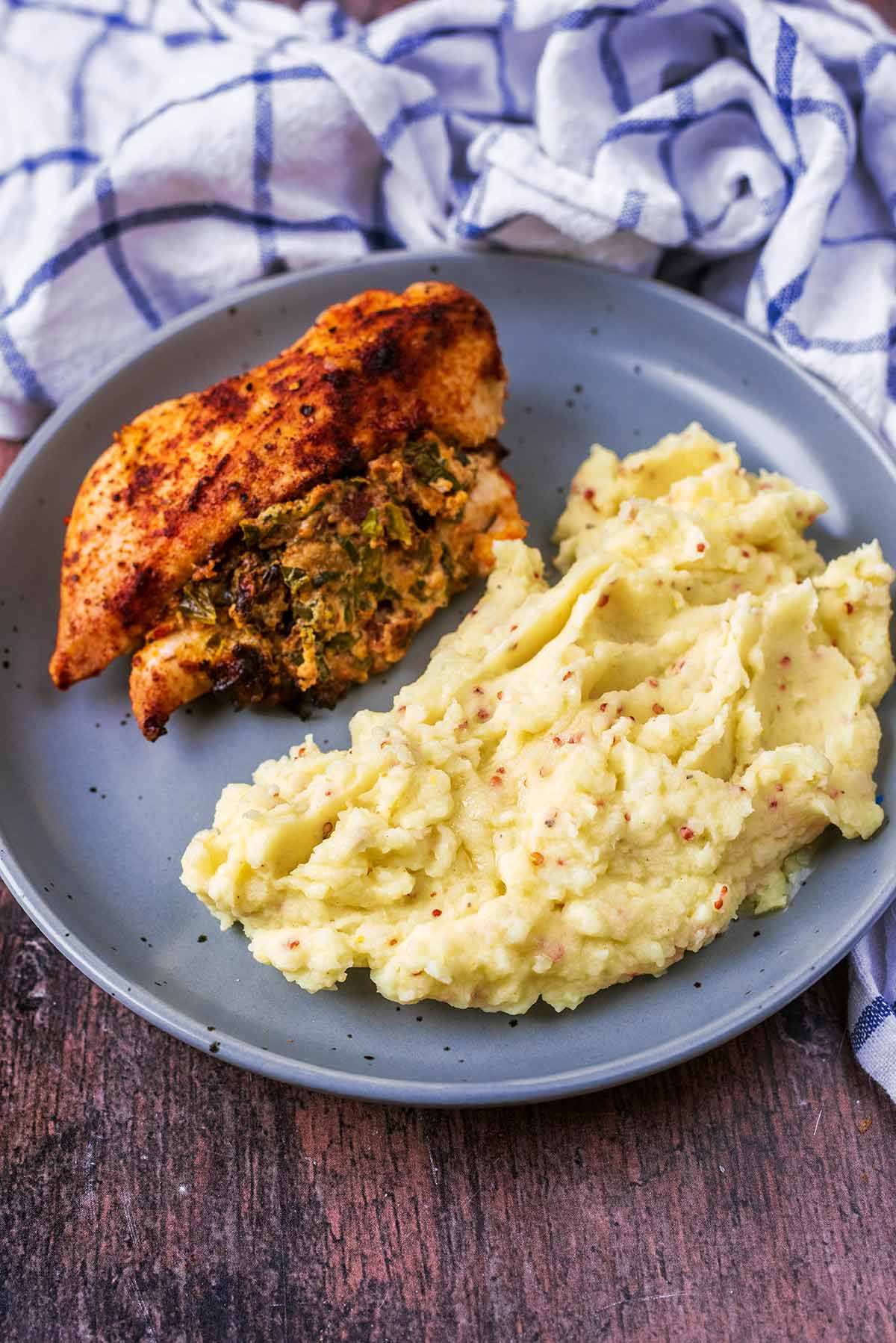 Mashed potato and a cooked chicken breast on a plate.