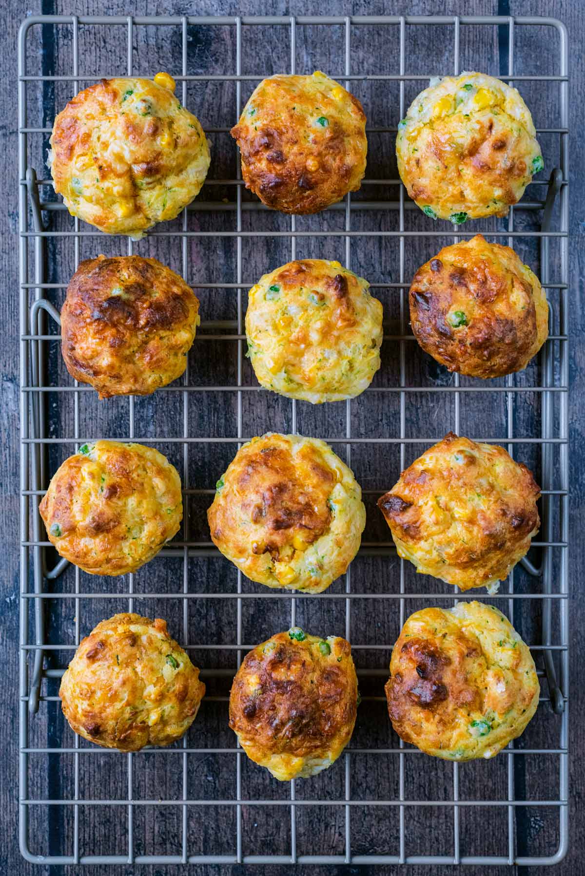 Twelve savoury muffins cooling on a wire rack.