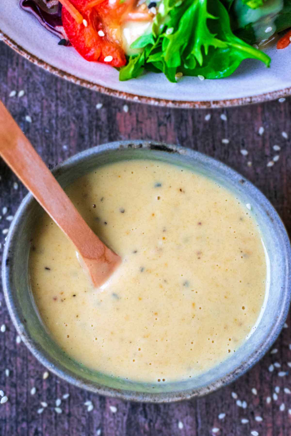 A creamy salad dressing in a small bowl with a spoon.