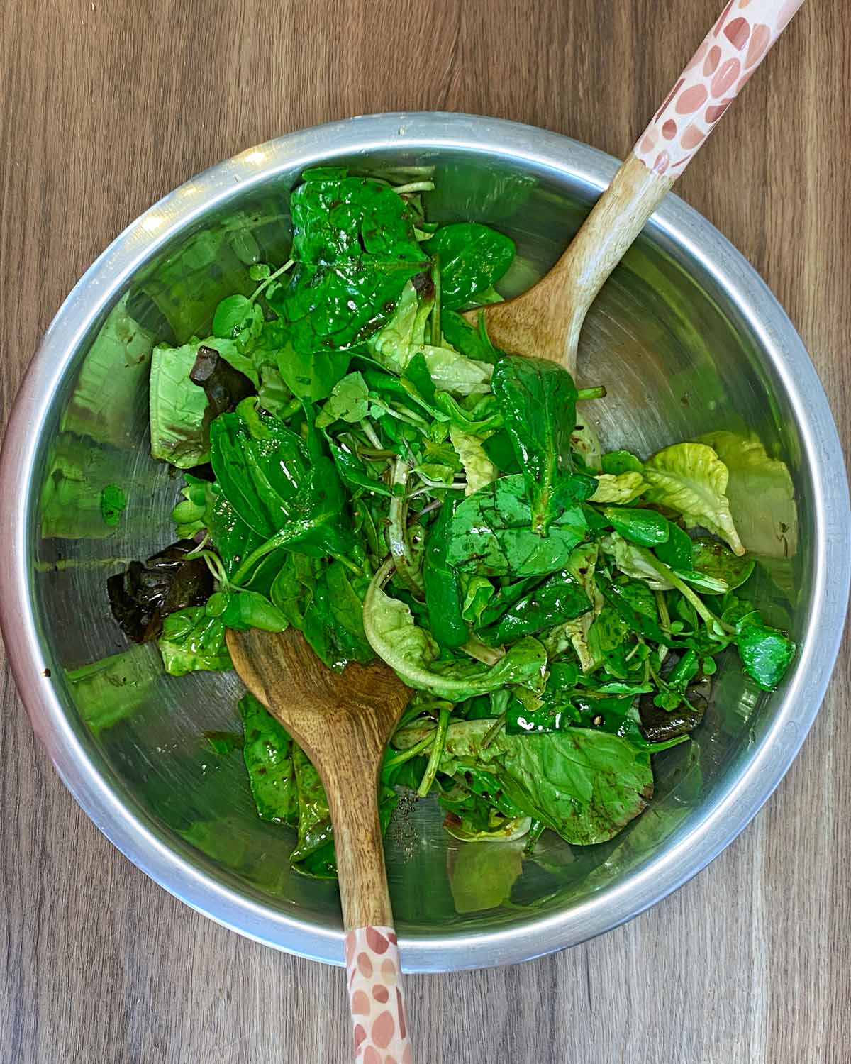 A bowl of salad leaves in an oil based dressing.