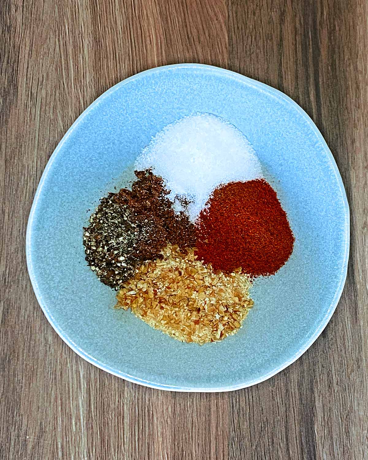 A bowl containing various spices and seasonings.