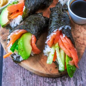 Hand roll sushi on a wooden board.