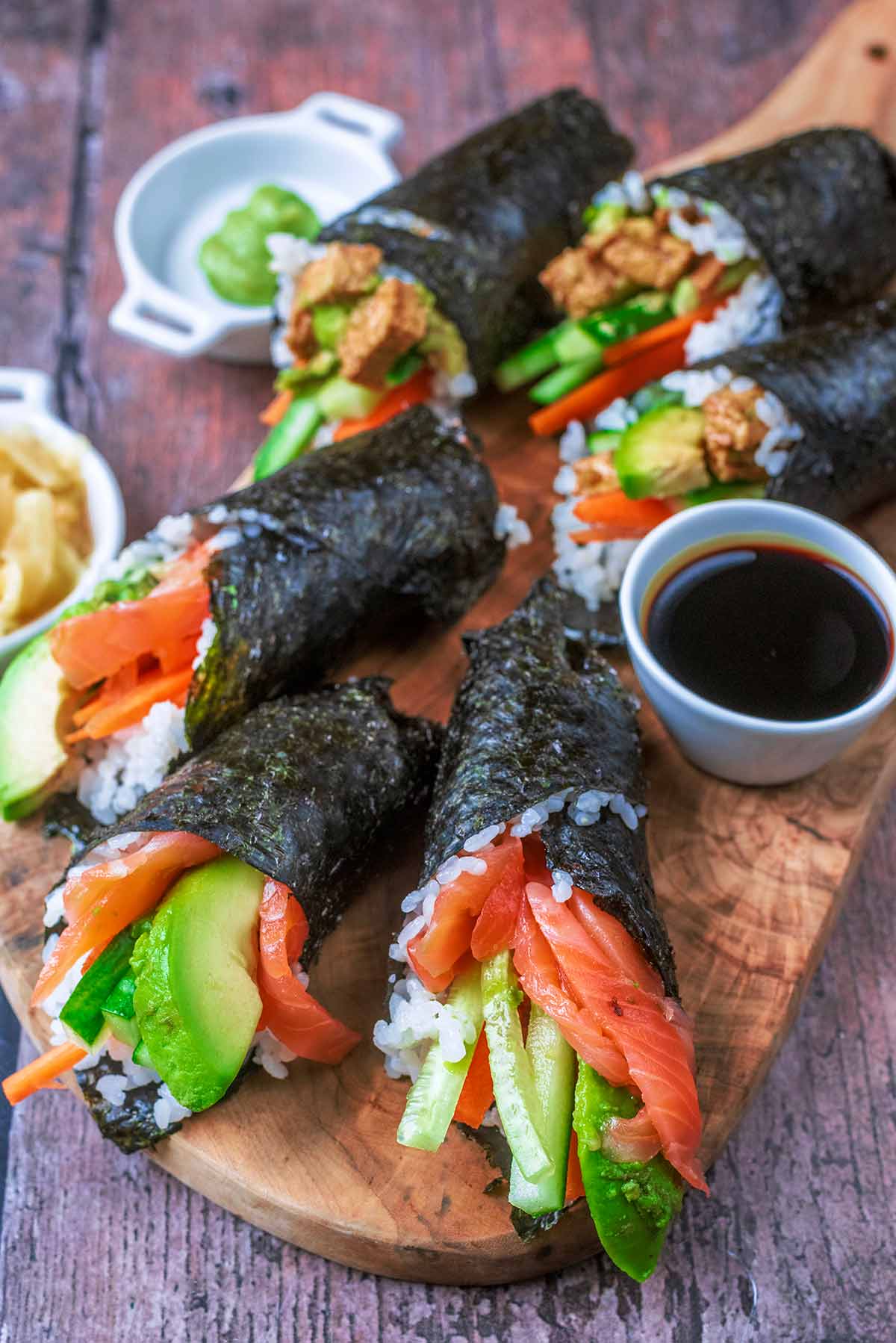 Three salmon and three tofu filled sushi hand rolls.