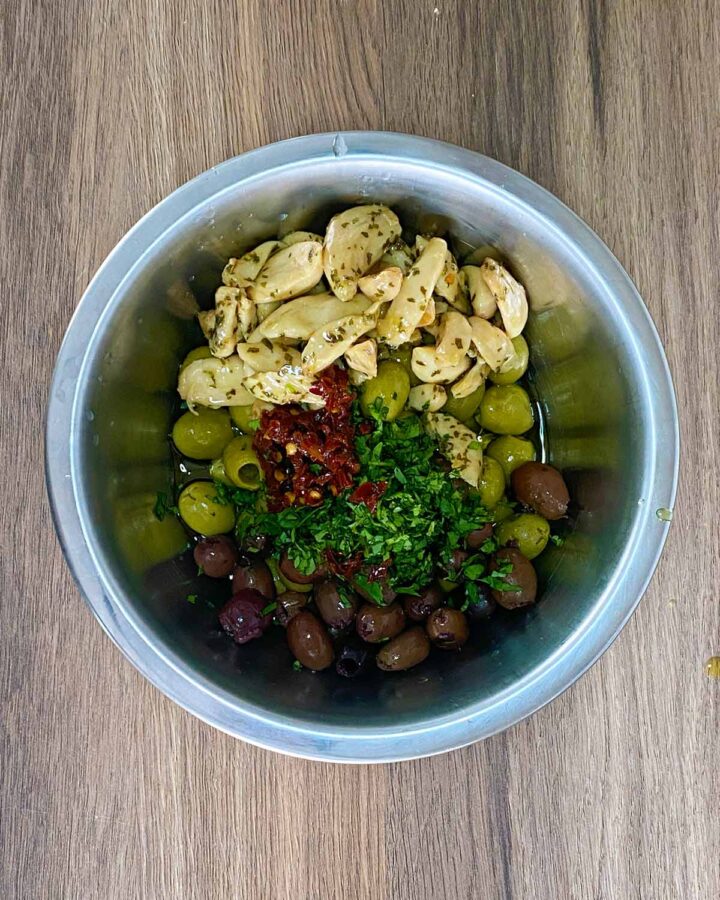 Oil, herbs and chilli added to the bowl.