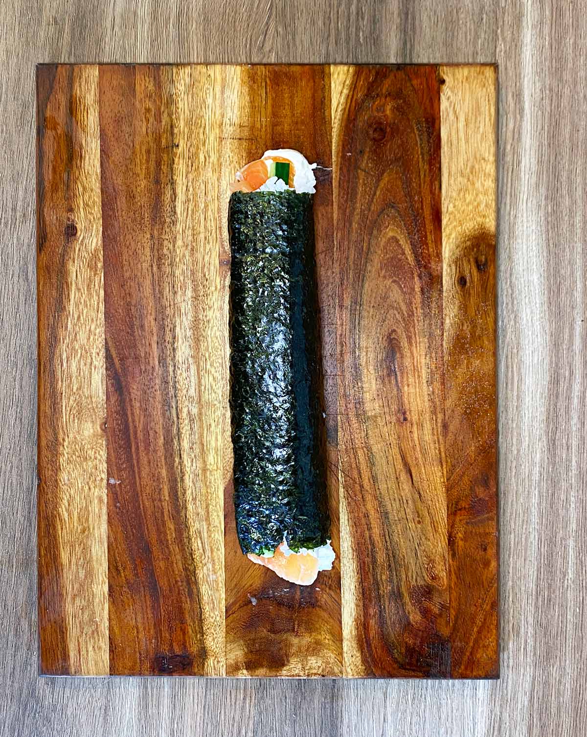 A fully rolled sushi roll in a full length.