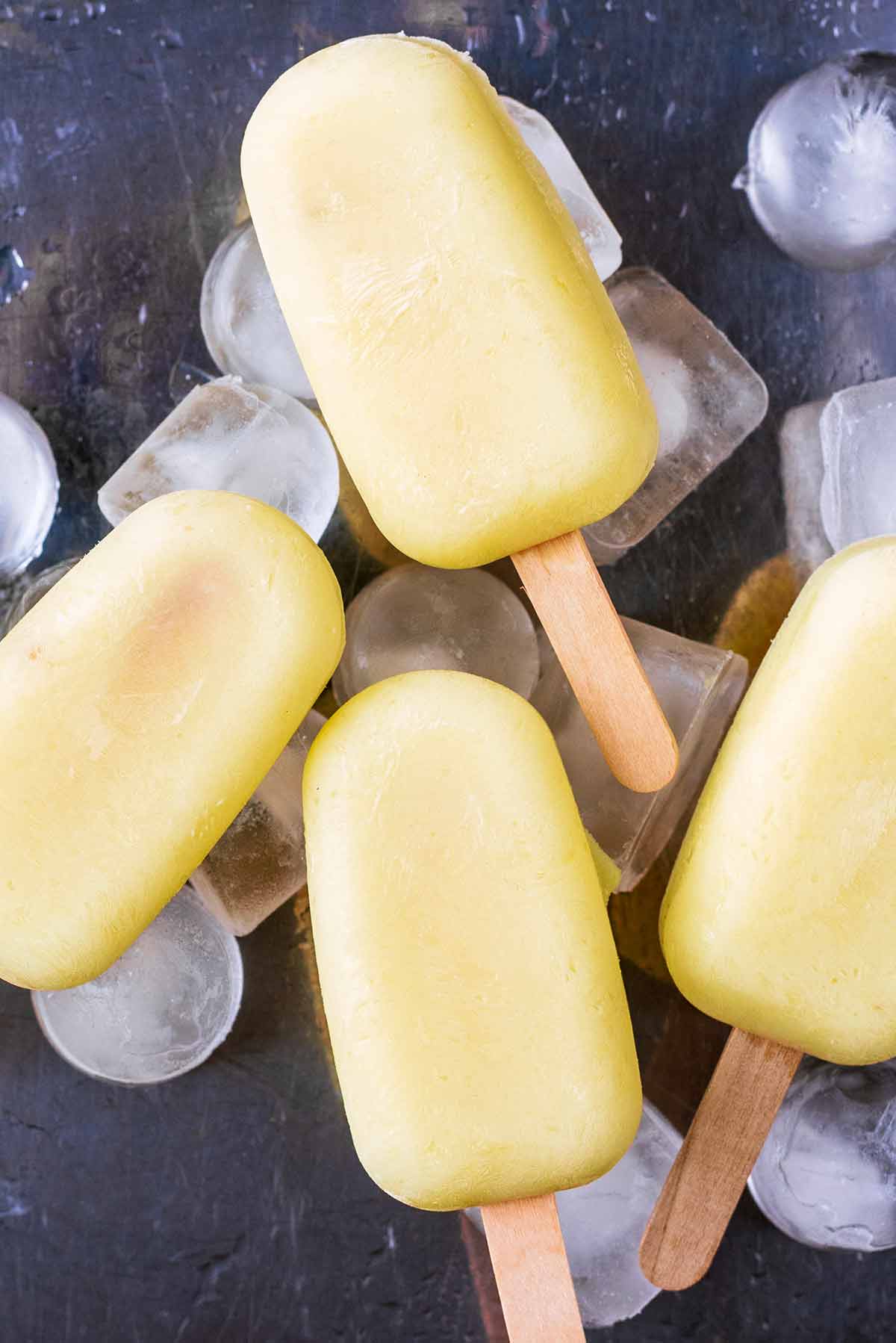 Pineapple lollies sat on some ice cubes.