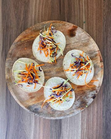 Four corn tacos with slaw on each of them.