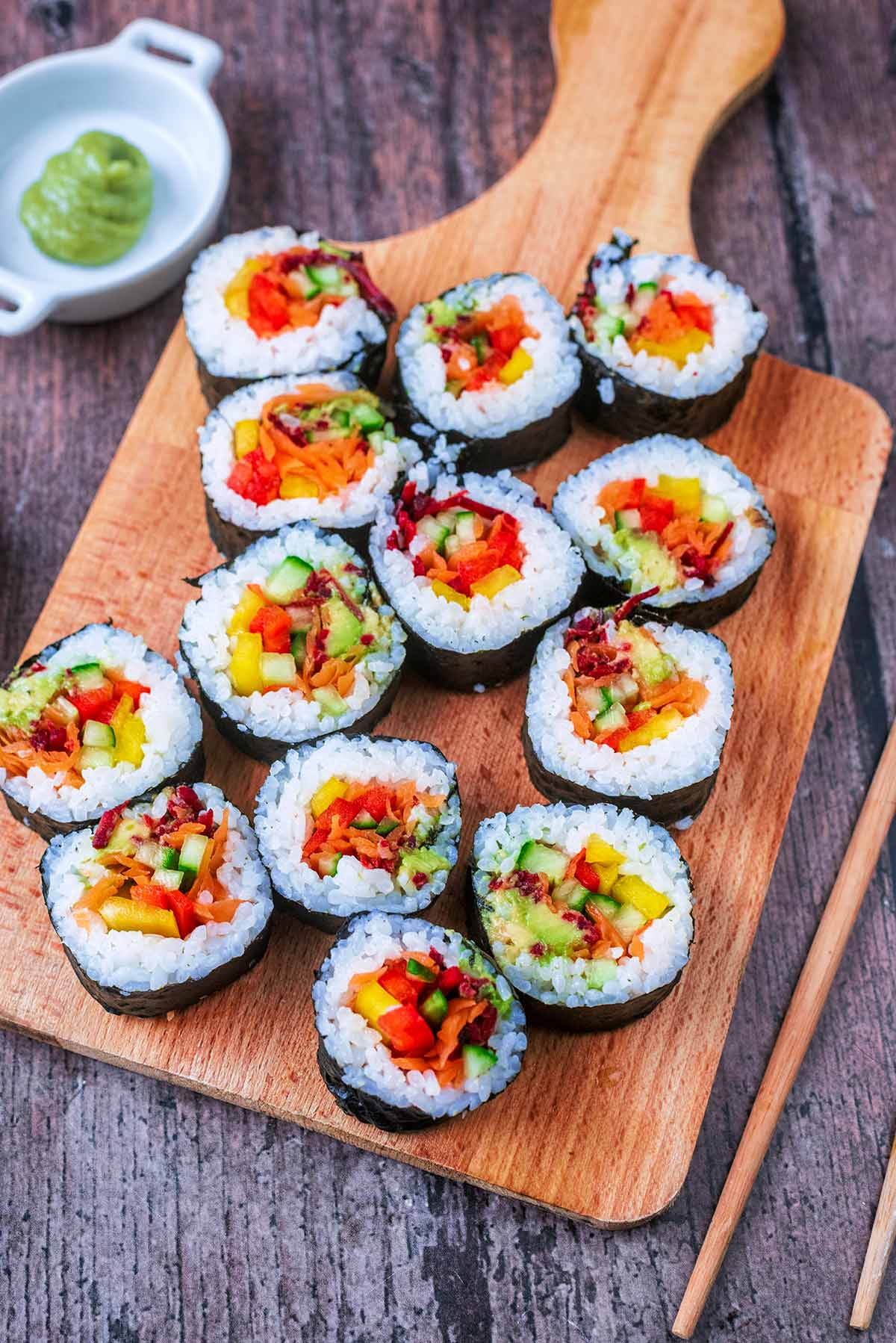 Colourful sushi rolls on a wooden serving board.