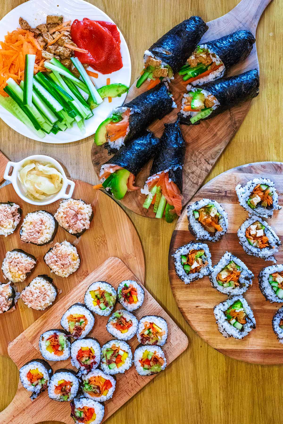 Various types of sushi on different wooden boards.