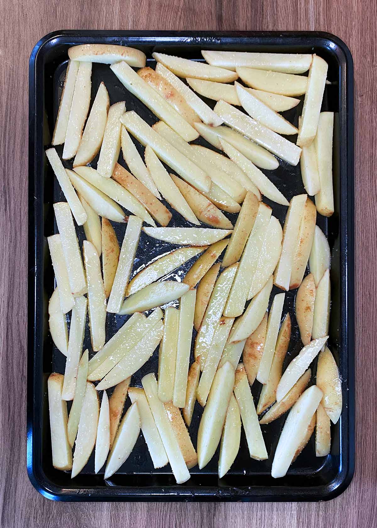 Uncooked chips laid out on a baking tray.