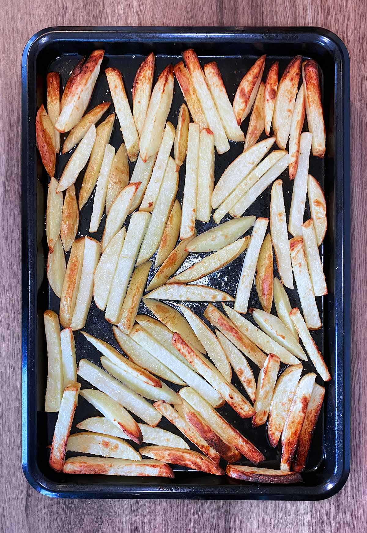 Cooked chips on a baking tray.