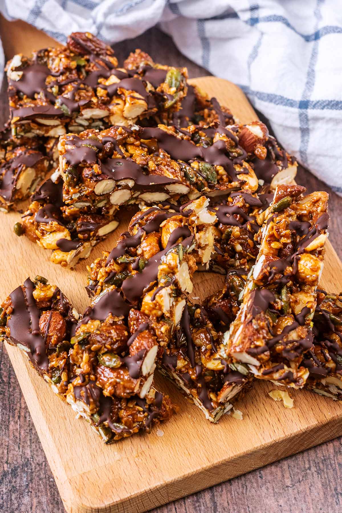 Nut bars piled up on a wooden serving board.
