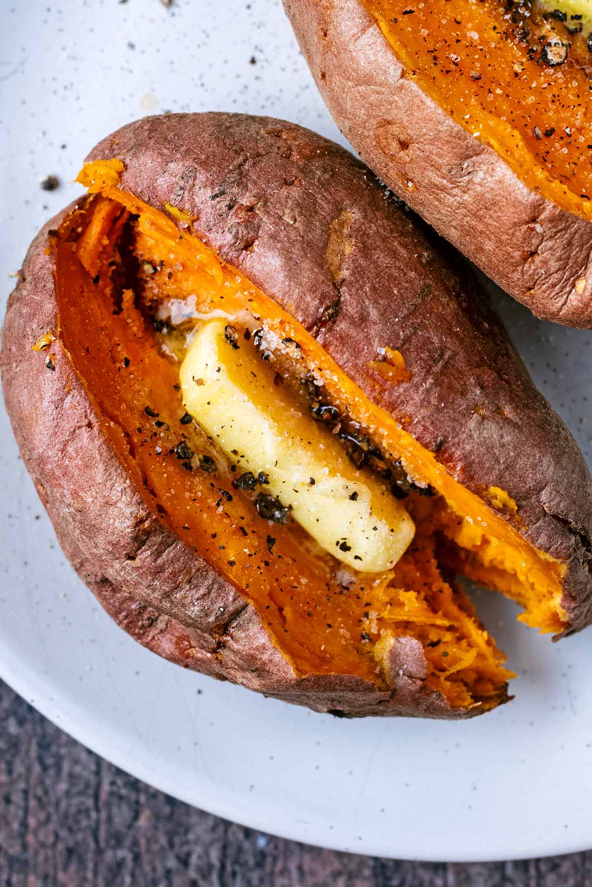 A pat of butter melting in a cooked sweet potato.